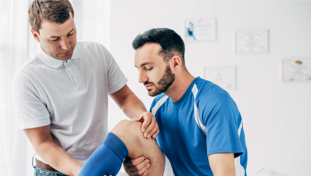 Doctor helping athlete with his knee pain