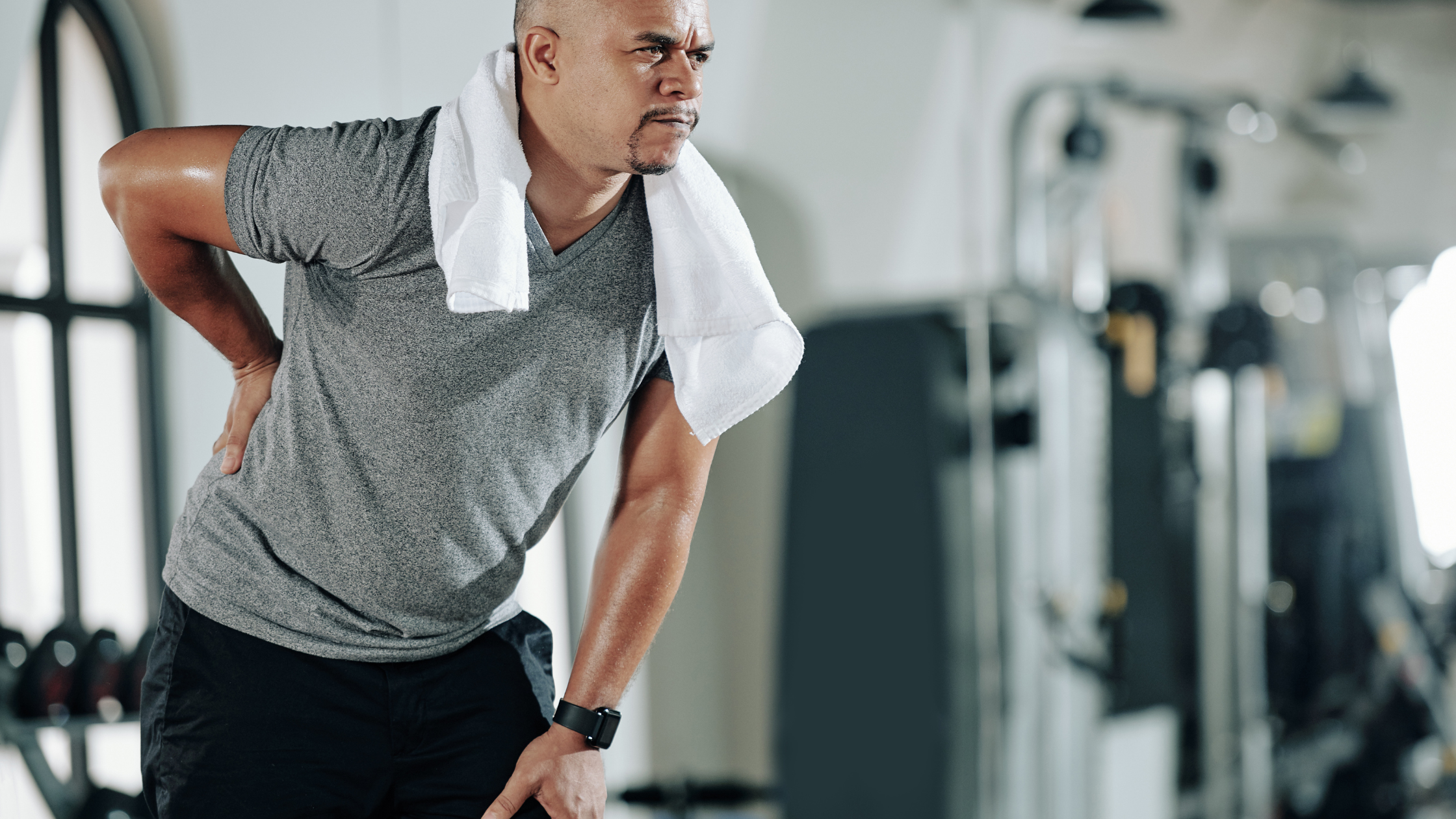 man in gym experiencing back pain